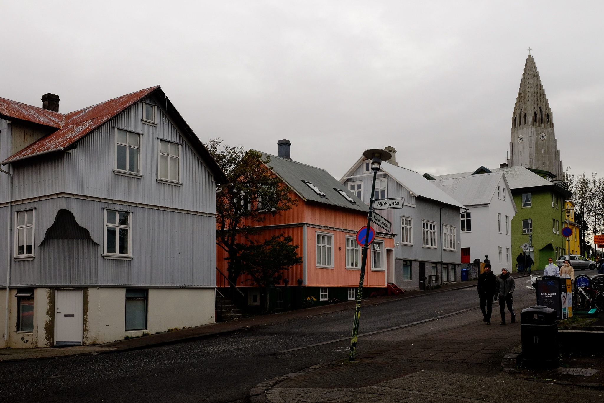 Hallgrimskirkja church up a road with an incline, the houses painted different colours