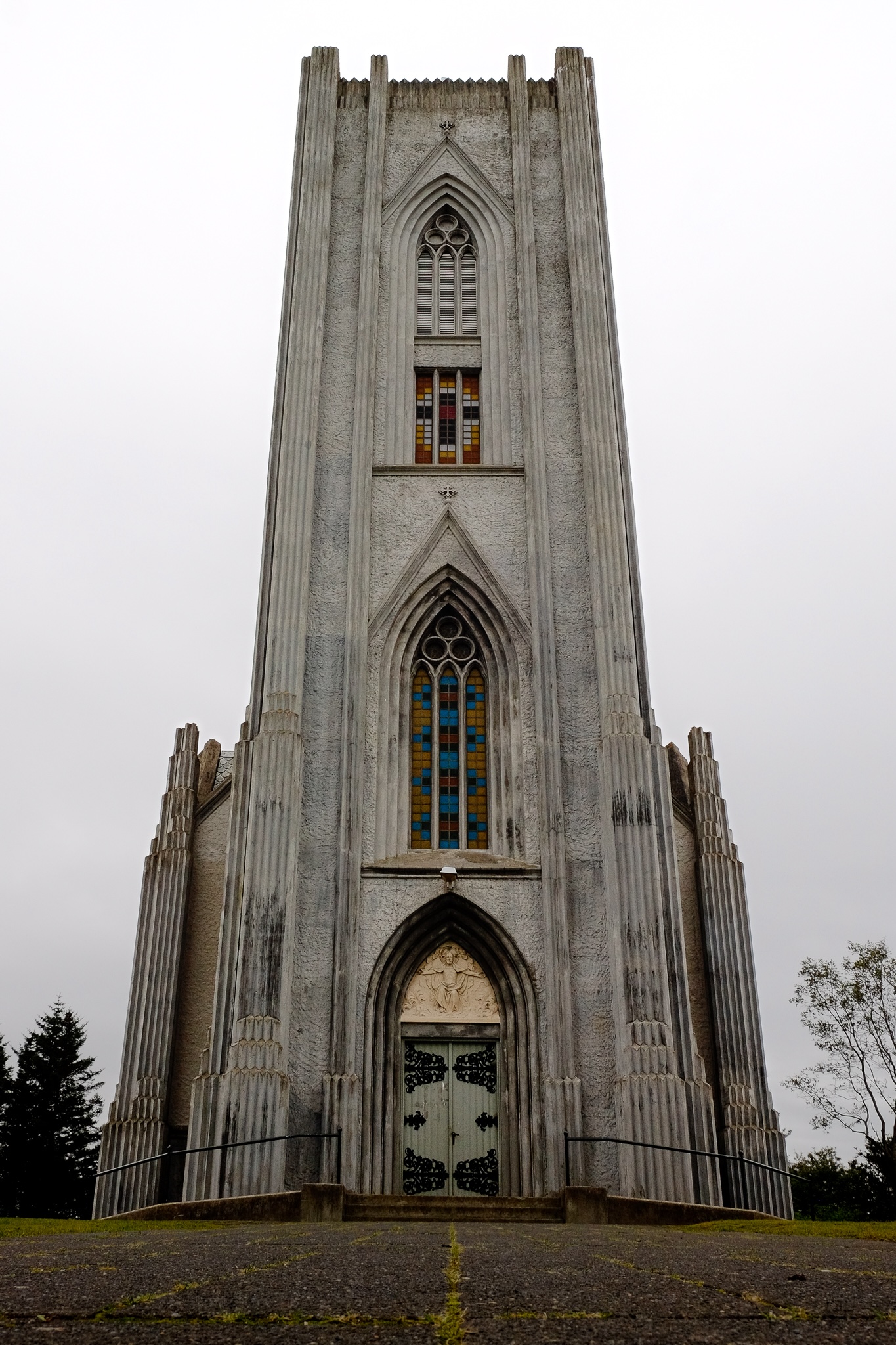 An imposing front on image of a church's steeple with nordic architecture and stained-glass windows