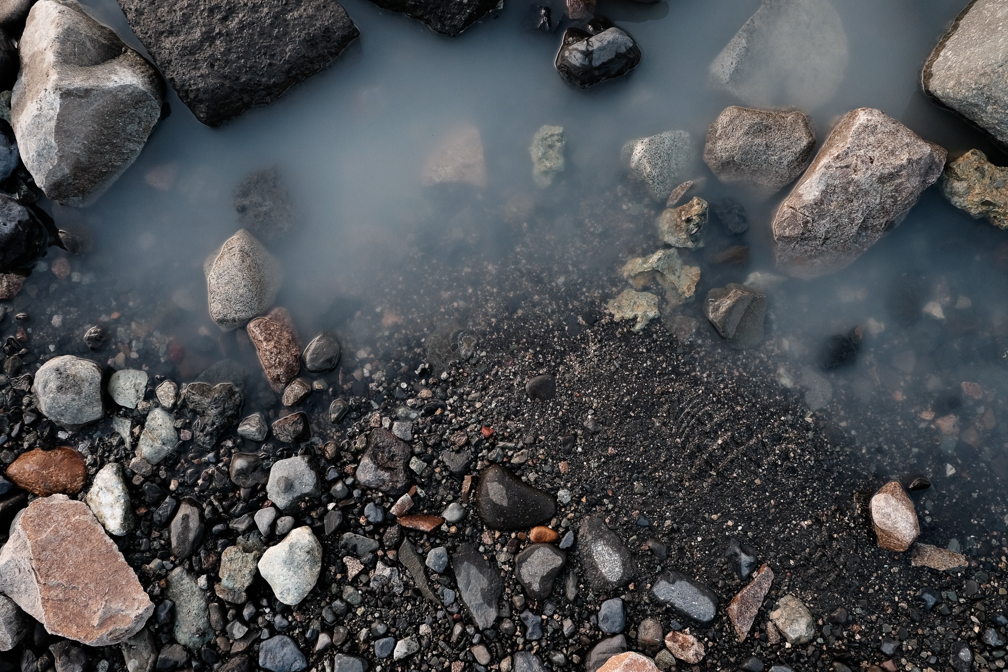 Milky mineral water and multi-coloured rocks of a glaciel lake