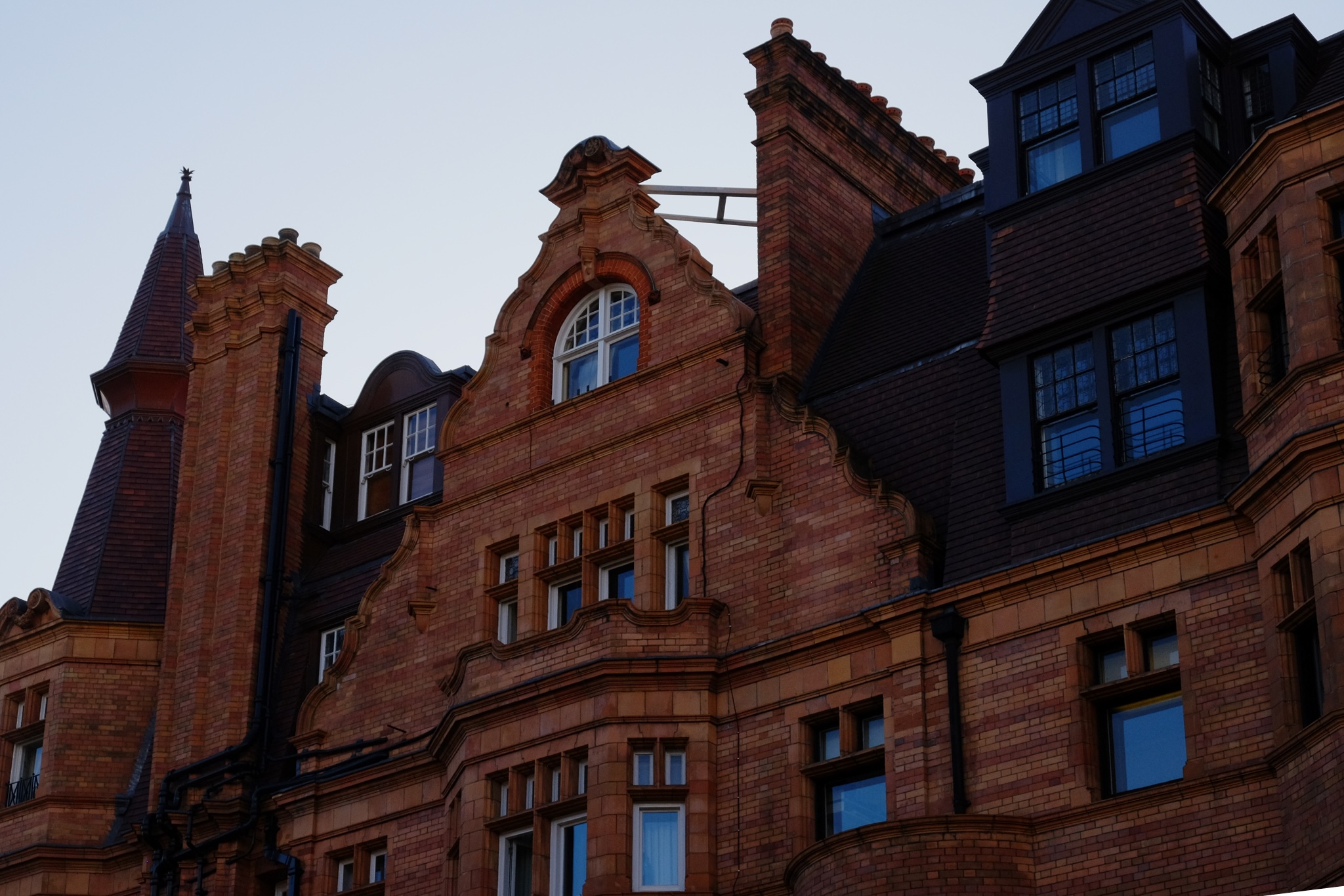 Red brick building with the blue sky reflected in the windows popping with colour
