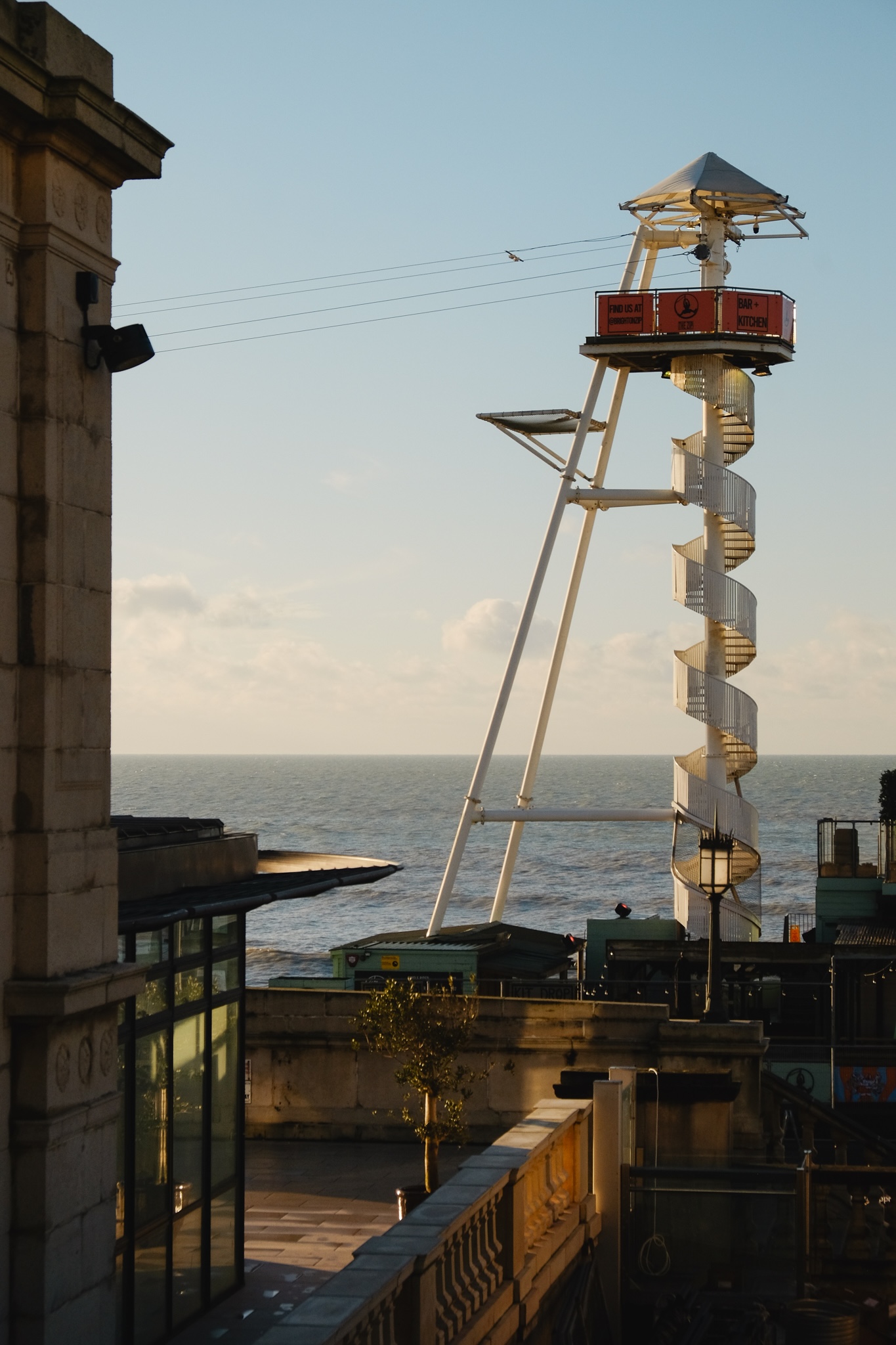 A tall circular staircase leads to a zip line you can take down the beach